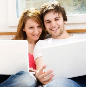 Closeup of couple looking at their laptop screens together