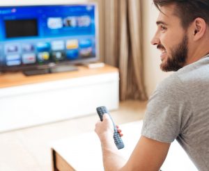 Attractive man with beard using TV remote