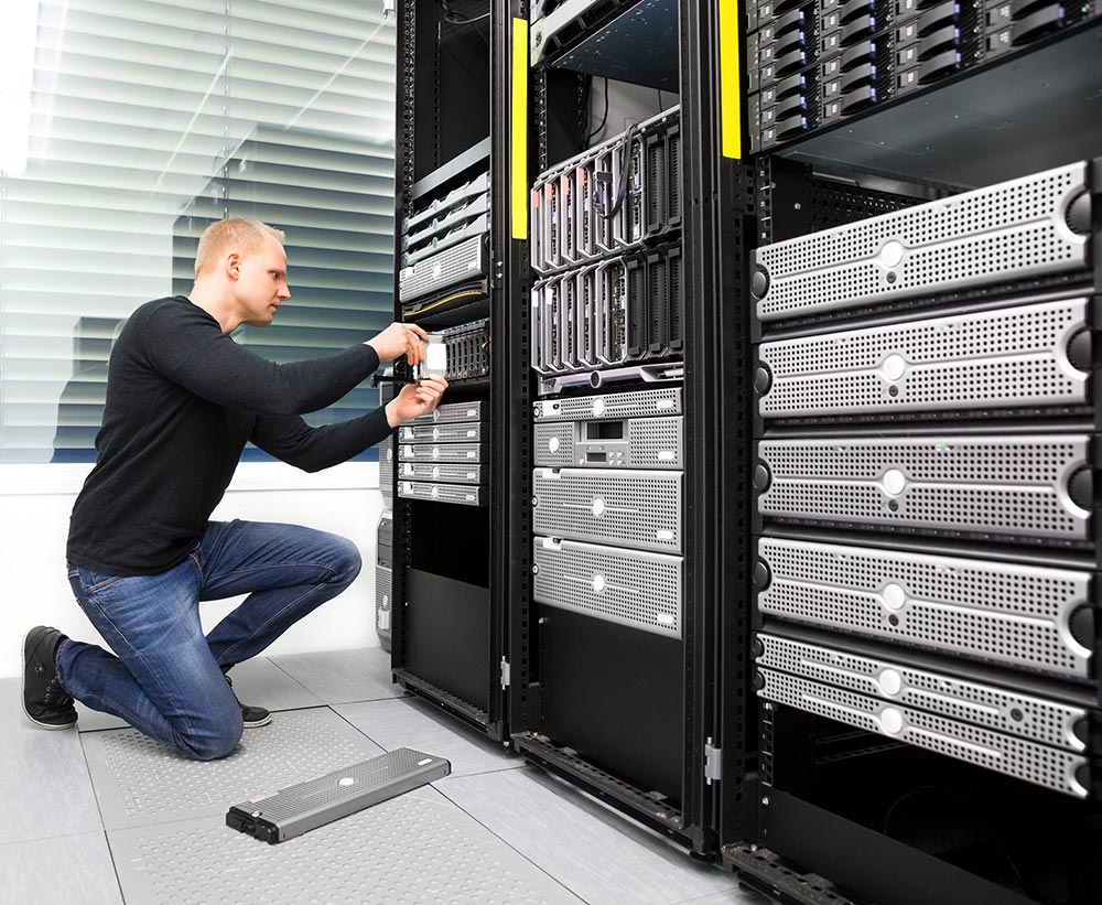 man replacing hard drive in datacenter